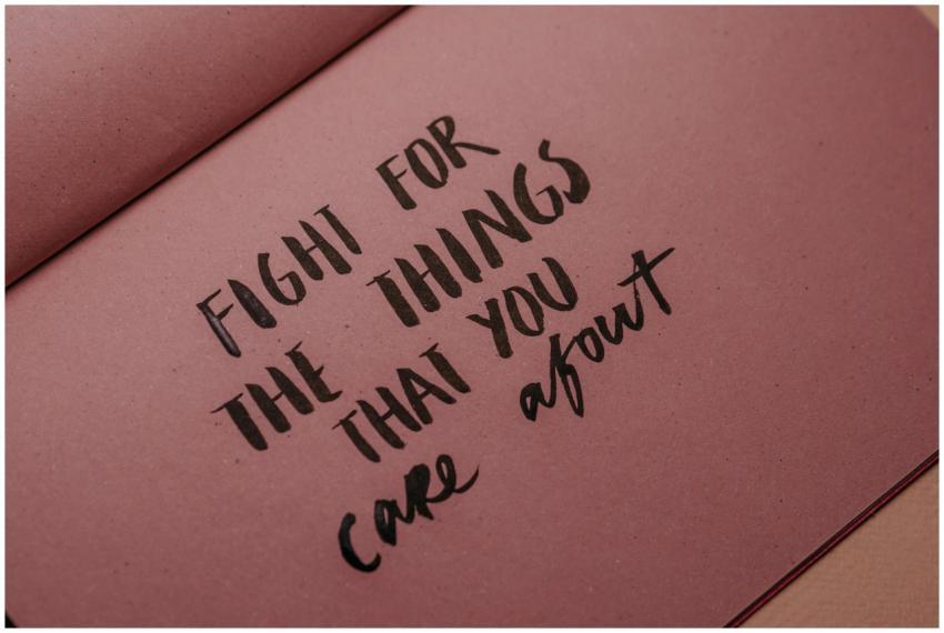 Hand-lettered inspirational quote on pink paper em