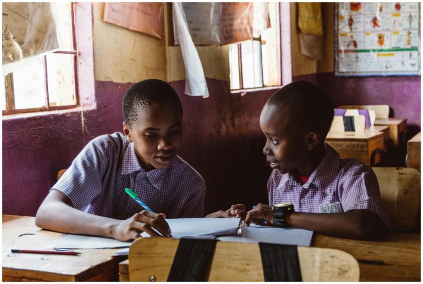Two boys collaborating on schoolwork in a classroo