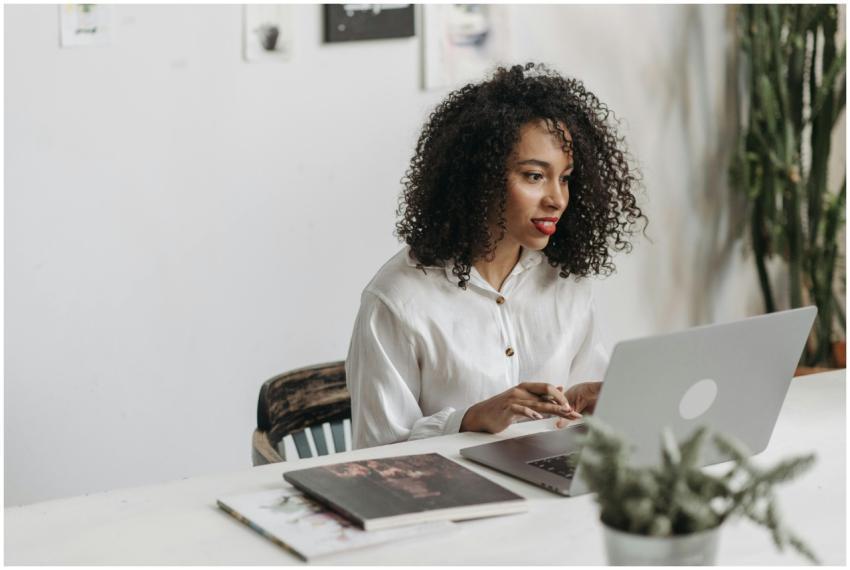 An African American woman with curly hair works at