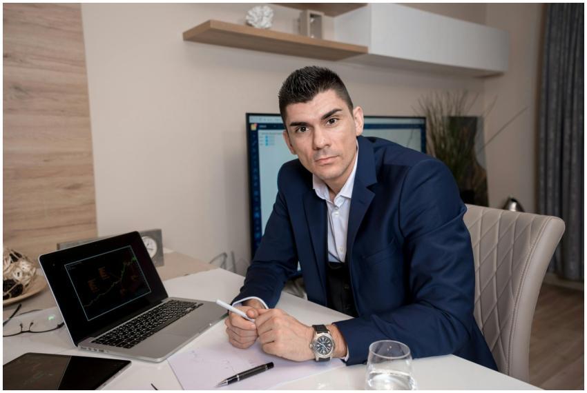 Businessman in blue suit working on laptop in slee