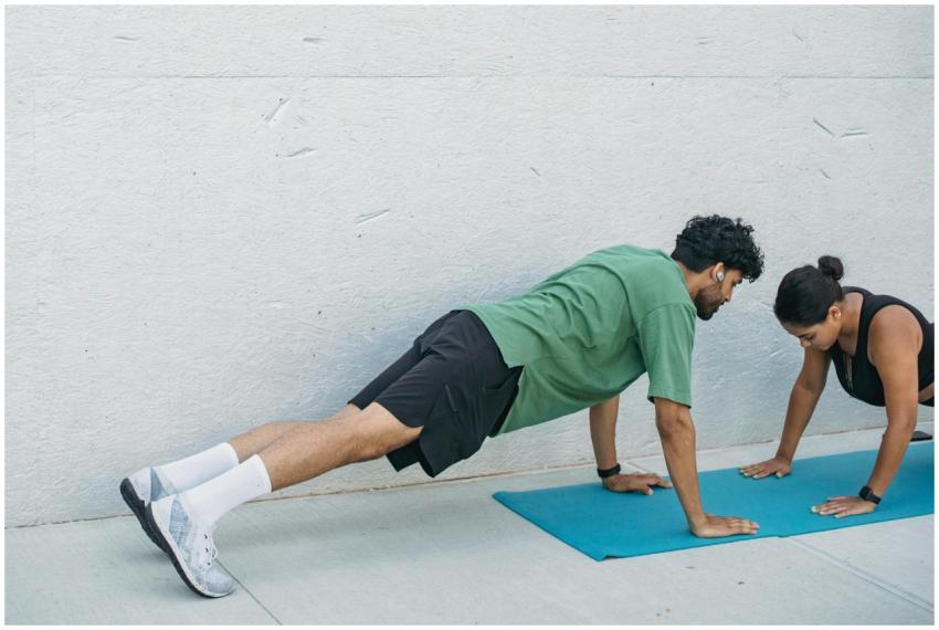 Man and woman practicing plank exercises outdoors