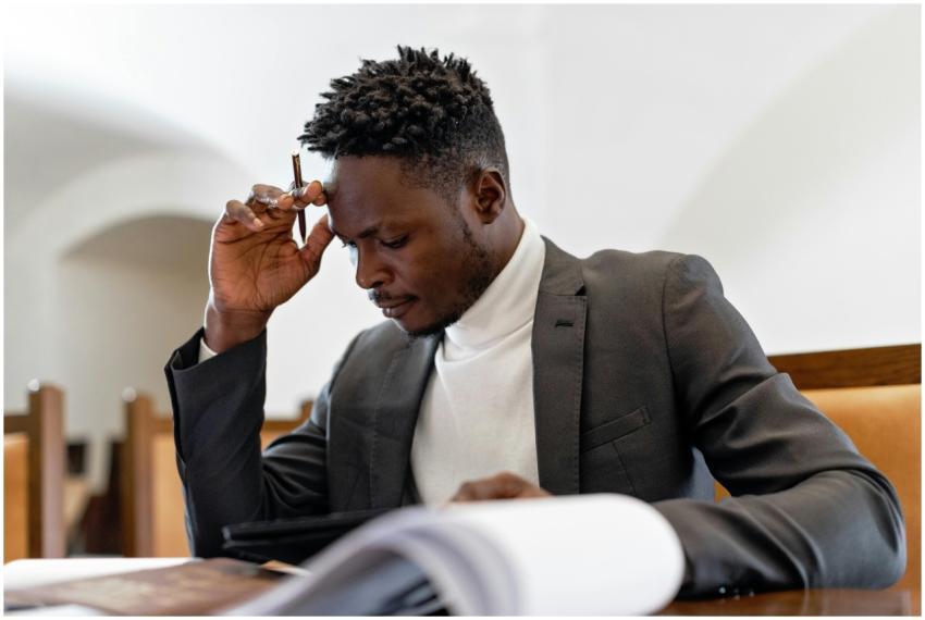 A focused businessman in a suit examines documents