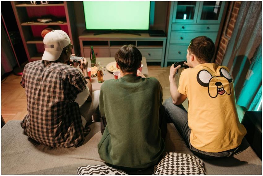 Three young men enjoying a home gaming session tog