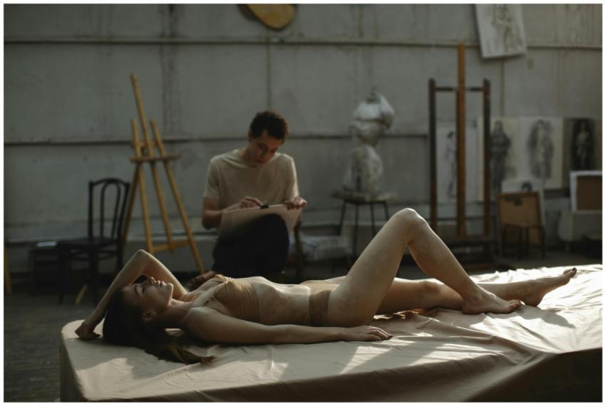 Artistic scene of a model posing nude in a studio