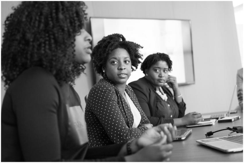 Three black women engaged in a serious discussion