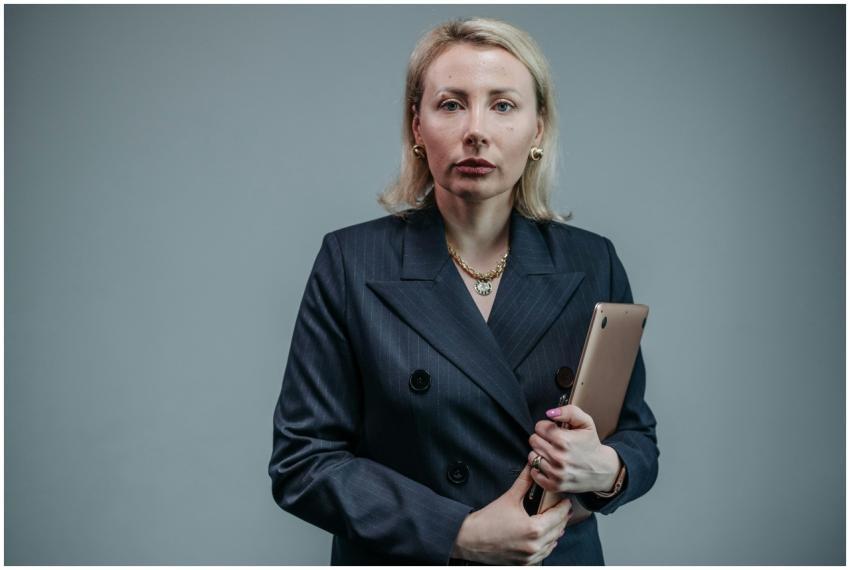 Blonde businesswoman in a black blazer holding a t