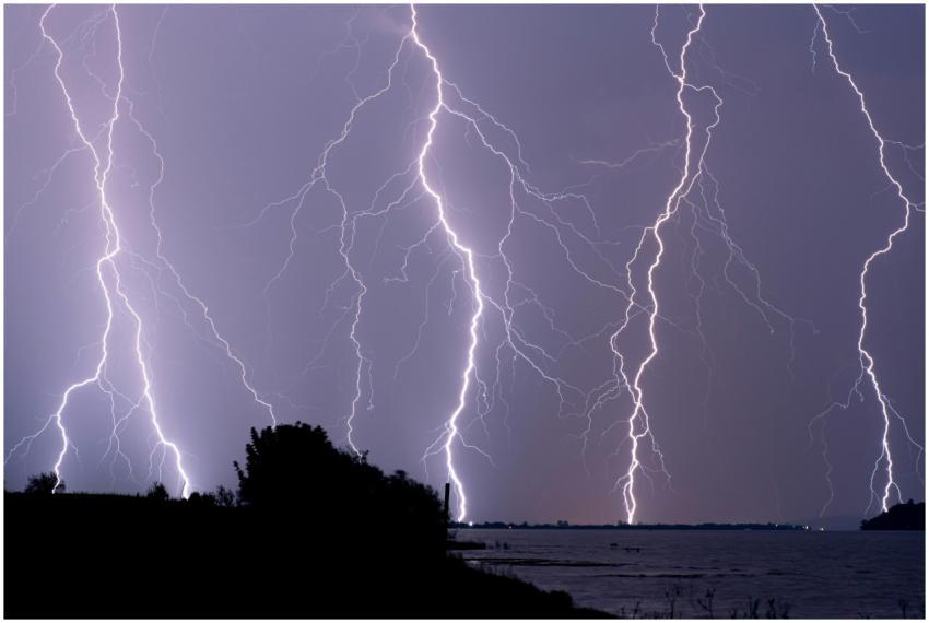 Lightning strikes over the ocean showcasing a dram