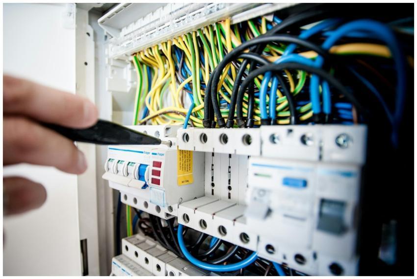 Hand of electrician working on a circuit breaker p
