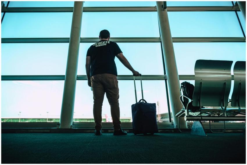 Man with luggage waiting at airport lounge, antici