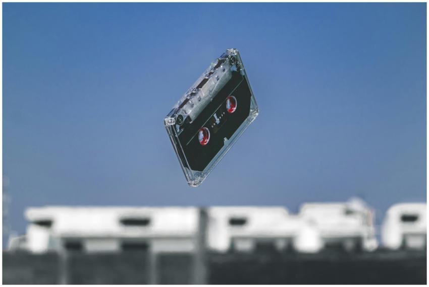 A retro cassette tape floats in mid-air with a blu