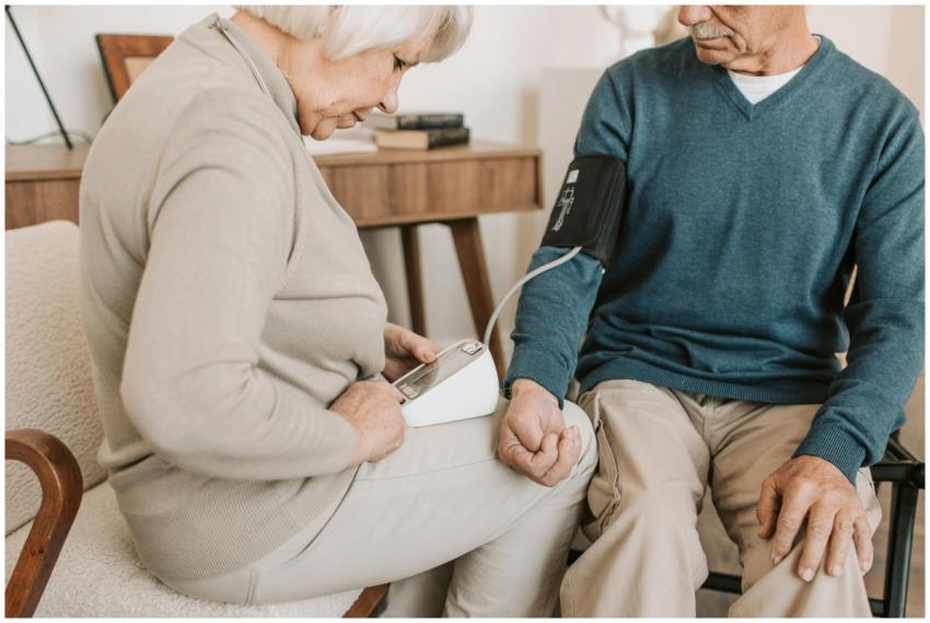 Senior couple at home measuring blood pressure for