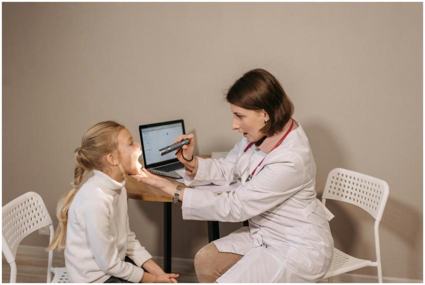 A female doctor examines a child in a clinic setti
