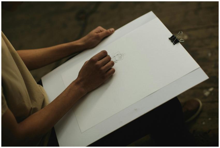 Artist focused on sketching a portrait in dim indo