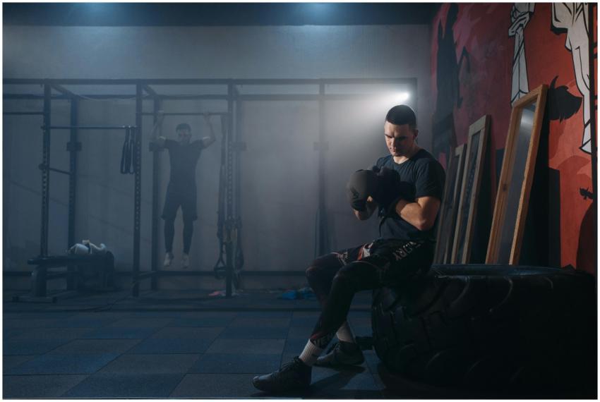 A focused boxer sitting on a tire, preparing for a