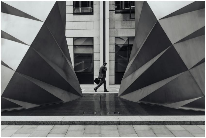 Monochrome photo of a businessman walking between