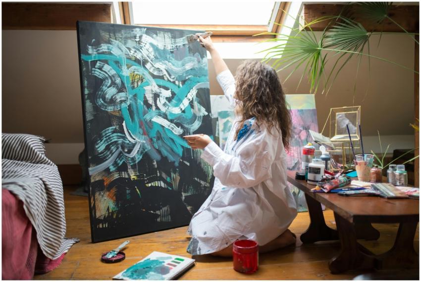 An artist creates abstract art on a large canvas i