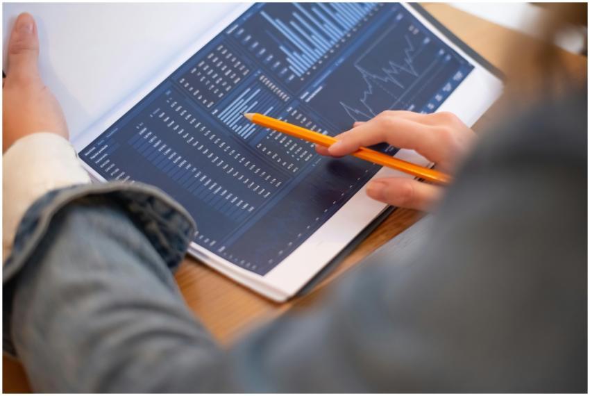 Focused image of hands analyzing business graphs a