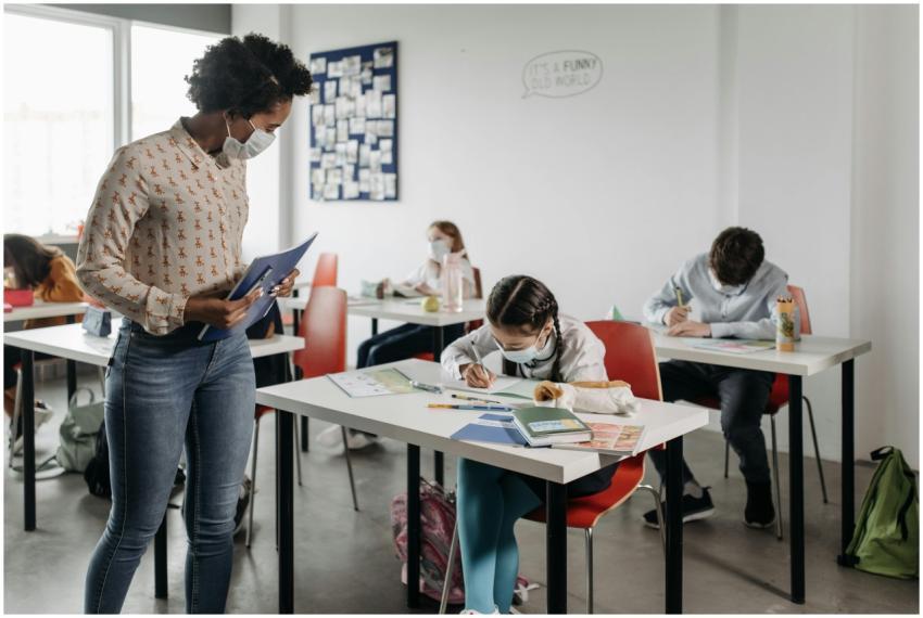 Students and teacher wearing masks in a diverse, m