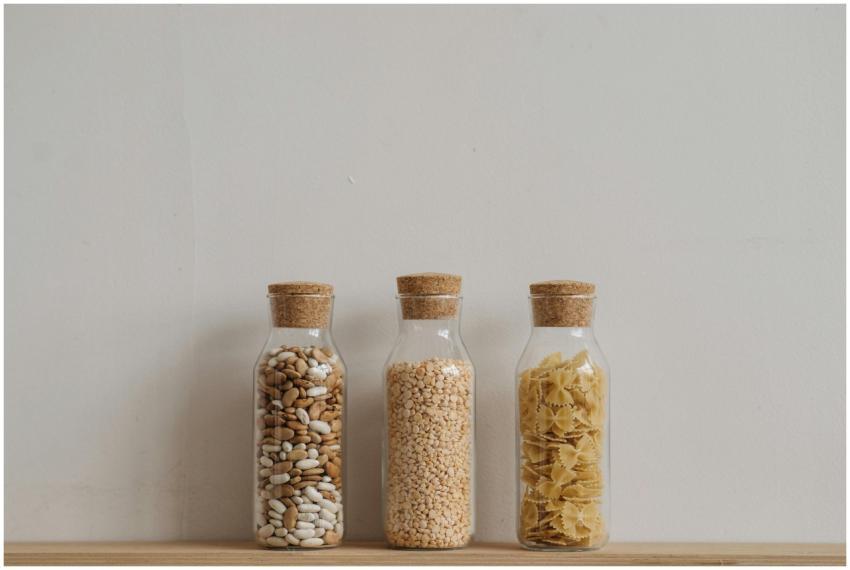 Three glass jars with cork lids holding beans, gra