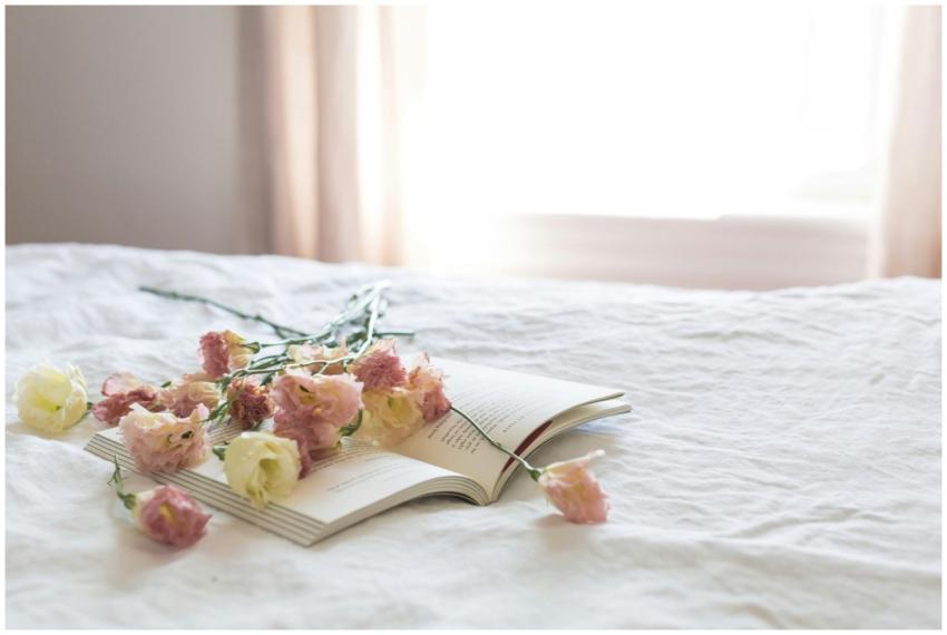 A serene bedroom scene with fresh flowers on an op
