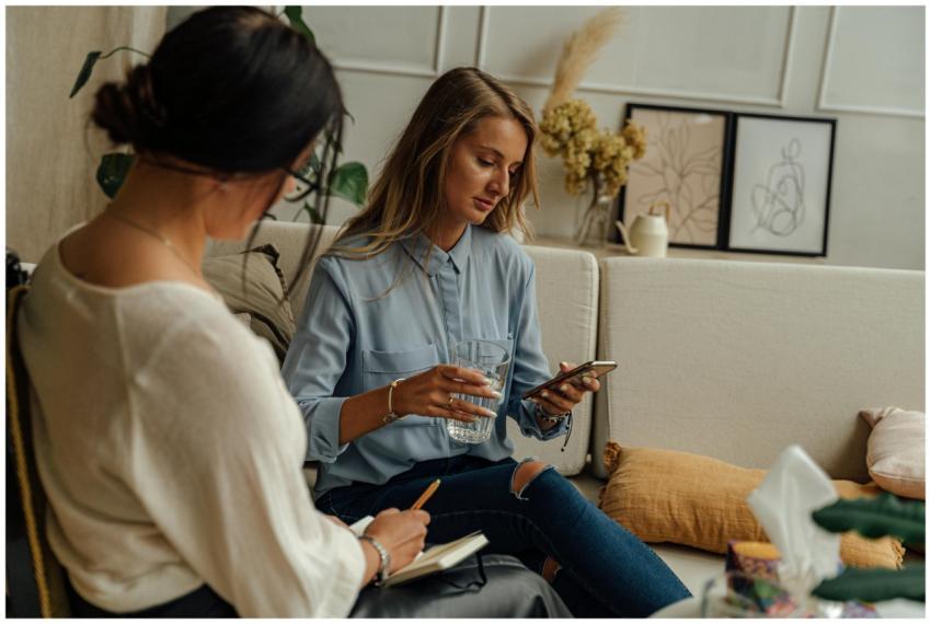 Two women engaged in a therapy session in a warm,