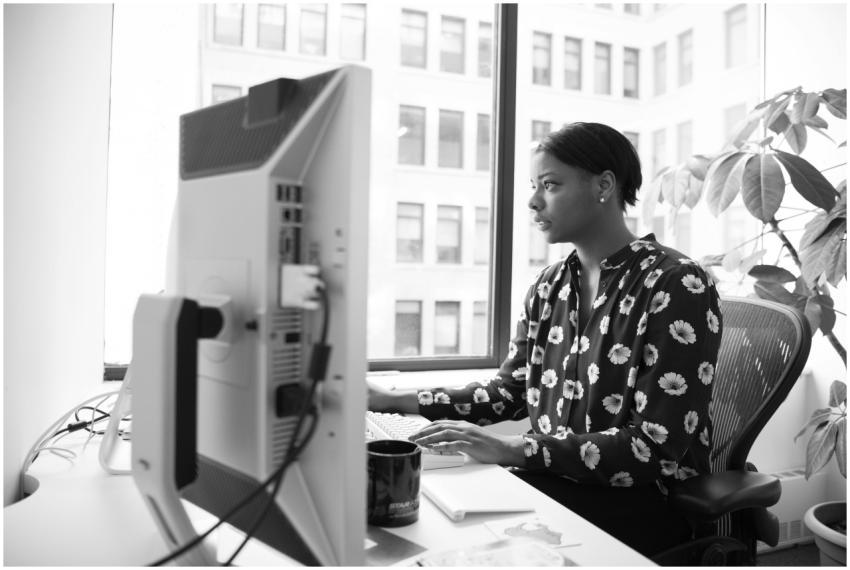 Black and white photo of a woman working at a desk