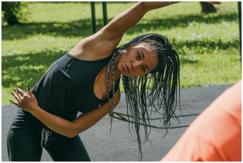 Young woman stretching in a sunny park for a fitne