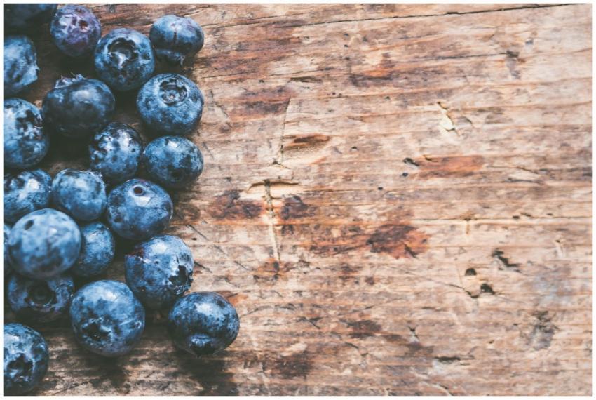 A close-up of ripe blueberries on a rustic wooden