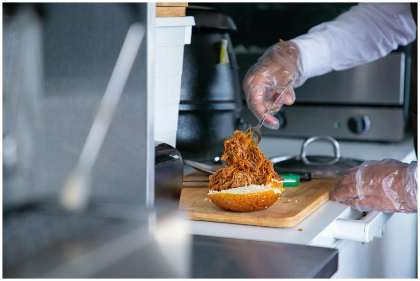 A chef uses gloves to prepare a delicious pulled p