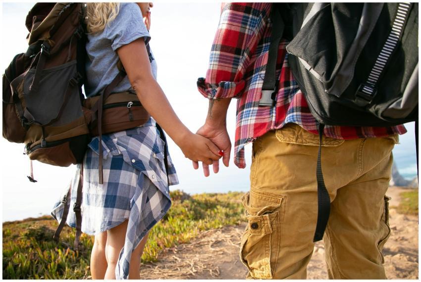 Close-up of a couple holding hands while hiking in