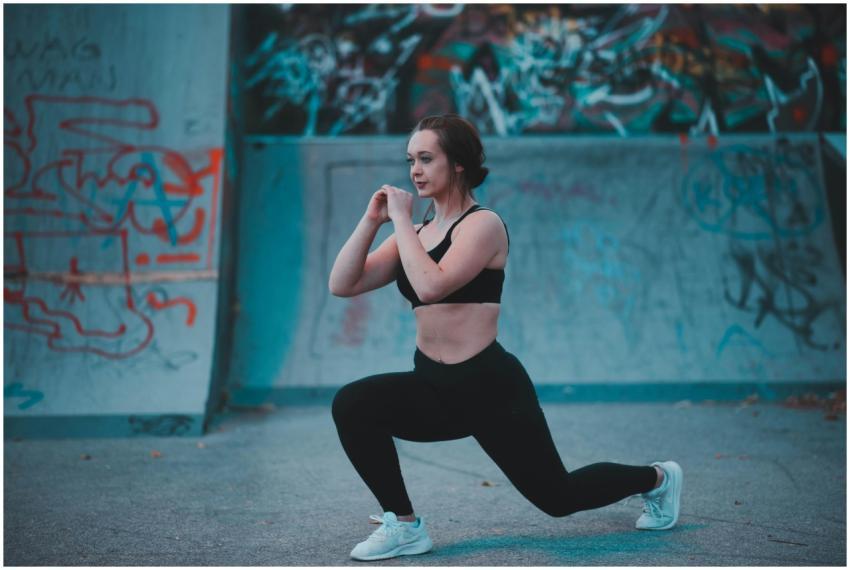 Confident woman in activewear performing lunges in