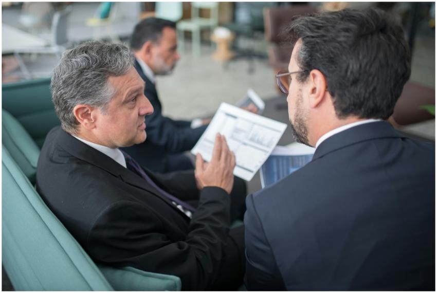 Two businessmen engaged in a discussion, examining