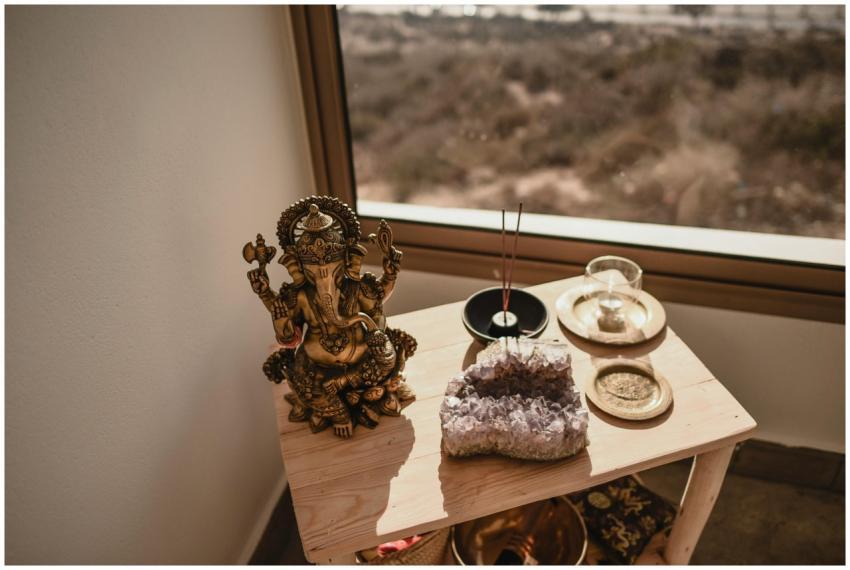 A Ganesha statue with incense sticks and an amethy