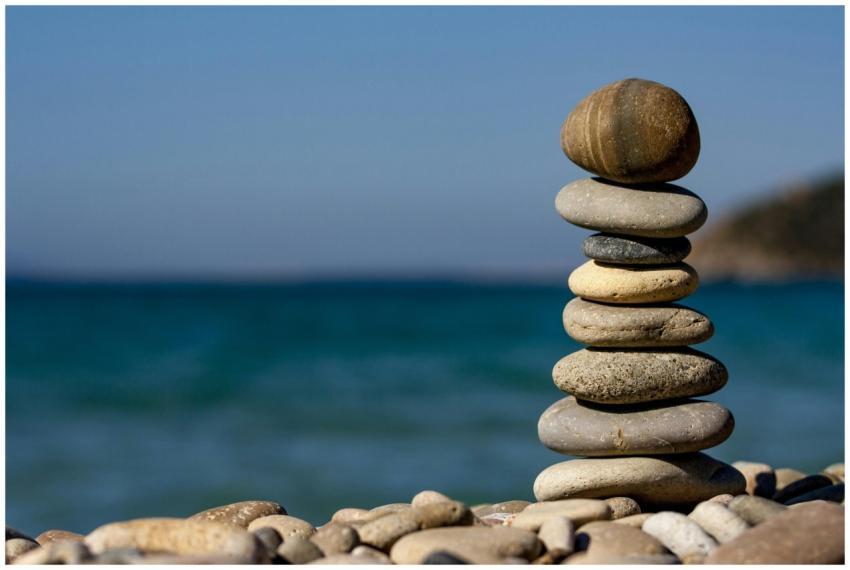 A stack of balanced stones on a beach with a tranq