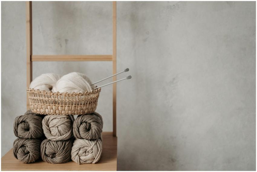 Handmade yarn and knitting needles on a wooden lad