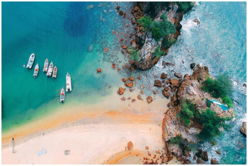 A stunning aerial view of boats anchored by a turq