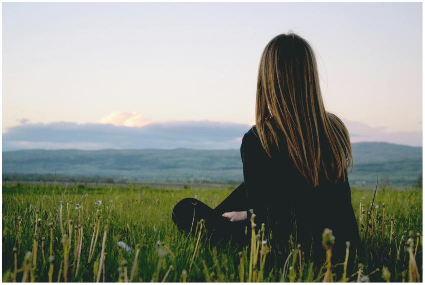 Woman enjoying peace in a lush green field with a