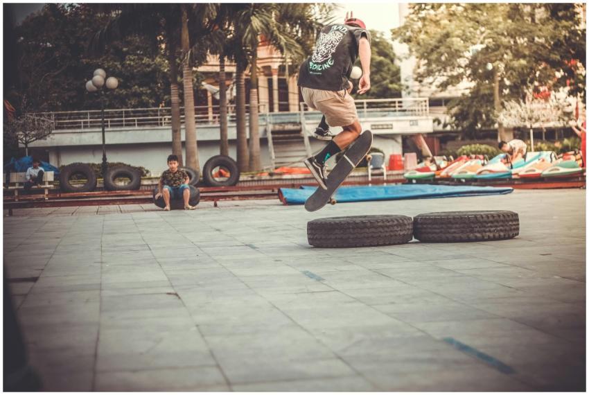 Skateboarder performs an aerial trick over tires i