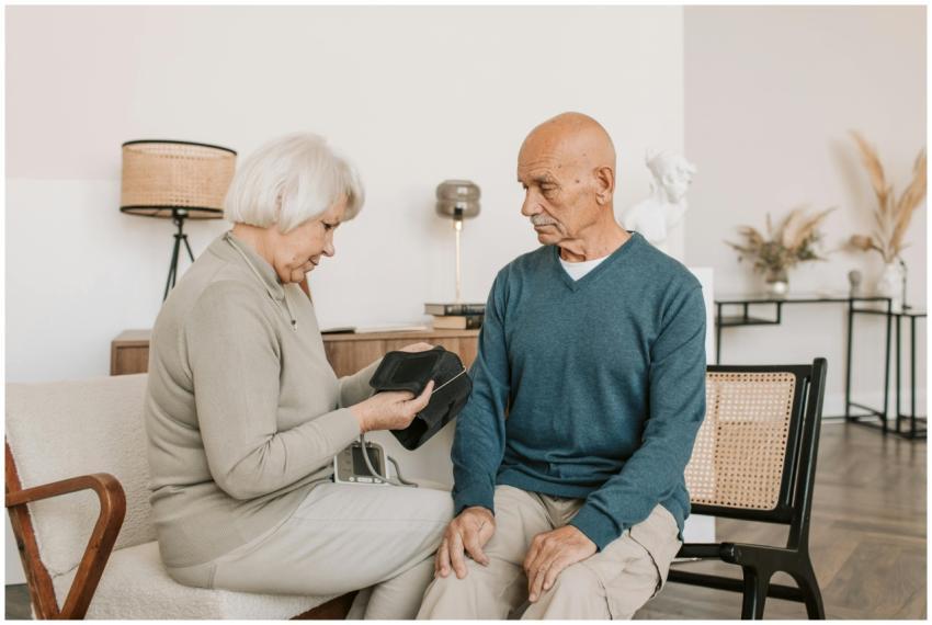 Elderly couple seated together, checking blood pre