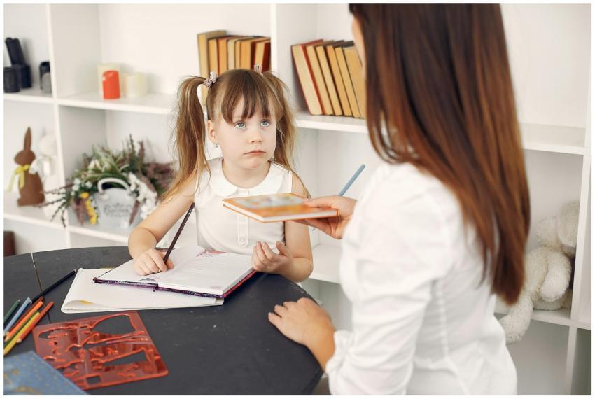 Young girl learning with a tutor at home, engaging