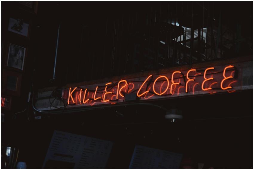 Bright neon sign 'Killer Coffee' in a dimly lit ca