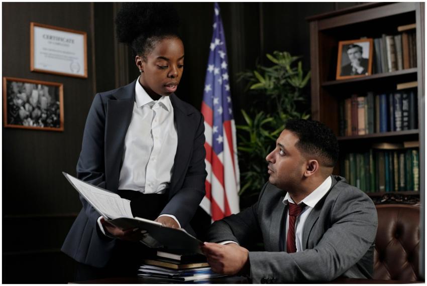 Two professionals discussing documents in an offic