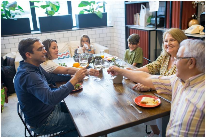 A joyful family gathering around a table, toasting