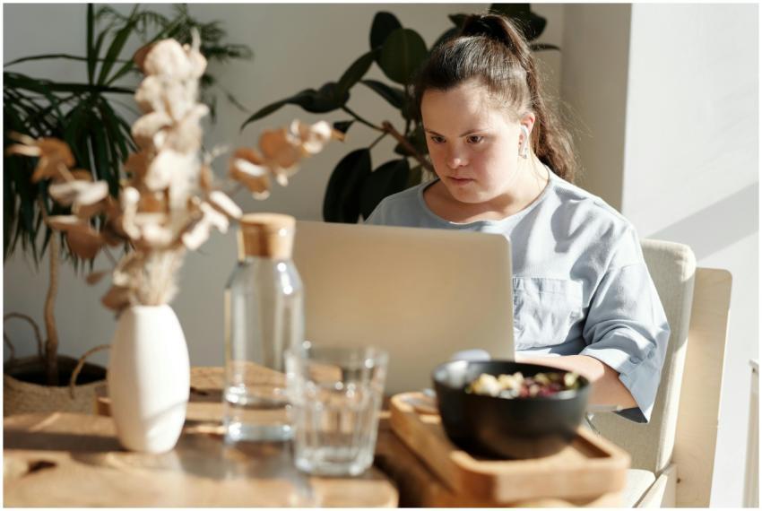 Young woman with Down syndrome using a laptop at a