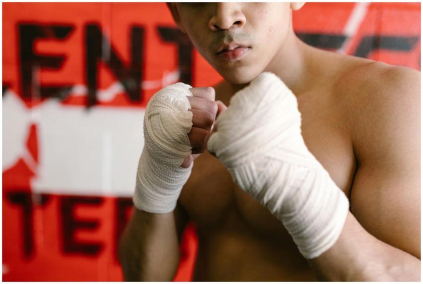 A focused boxer with clenched fists and hand wraps