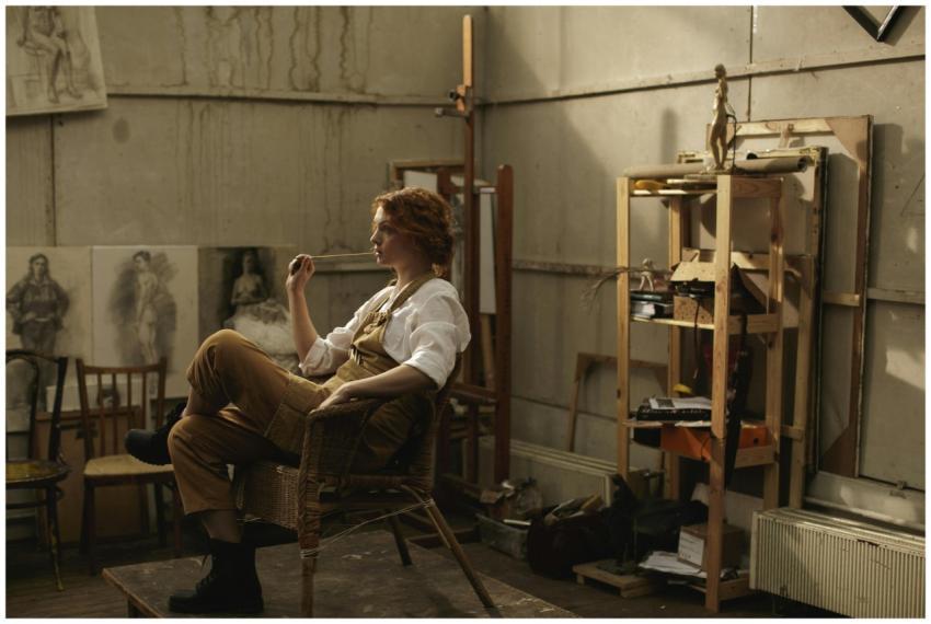 Female artist in a lofty art studio, lost in thoug