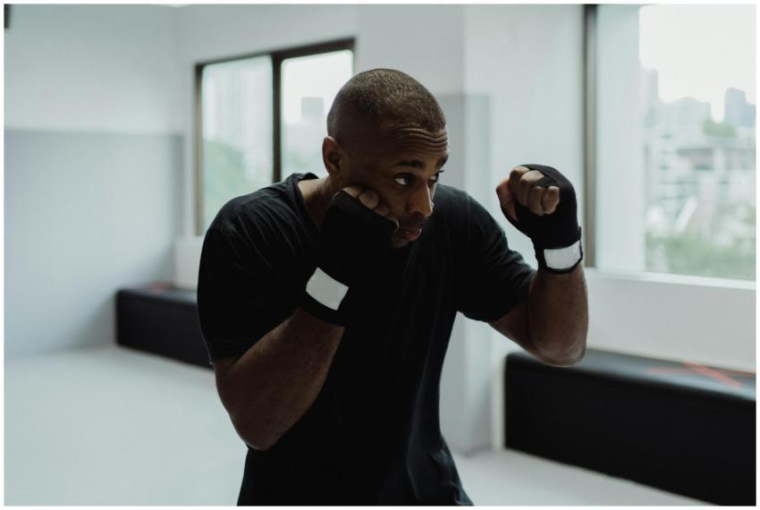 Man practicing boxing indoors. Focus on technique