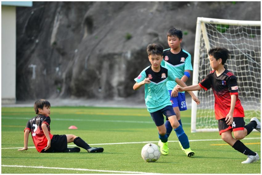Boys playing a lively soccer match on a sunny socc