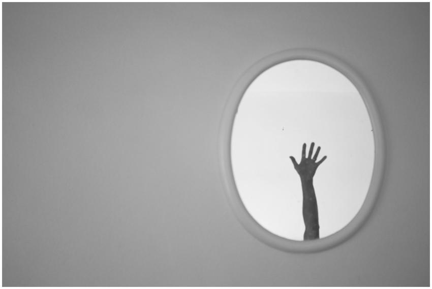 A monochrome image showcasing a hand reaching up i