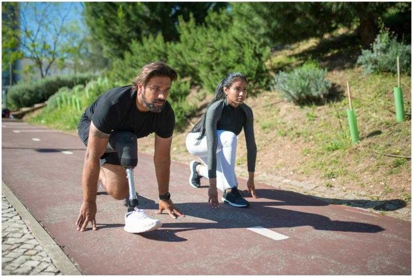 Two athletes preparing to start a run on a track,
